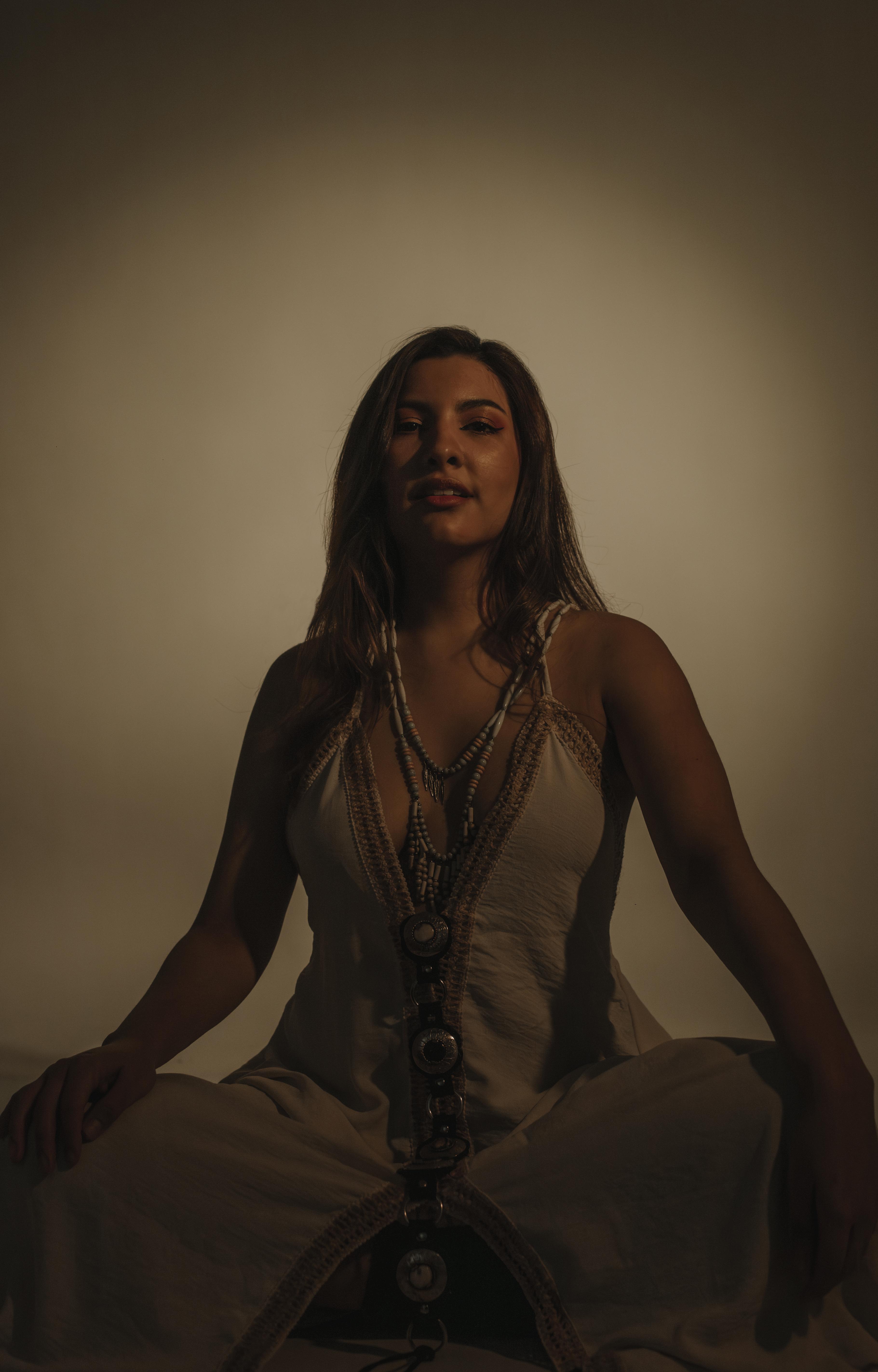 Savanna seated in a meditative pose, in soft violet and warm light