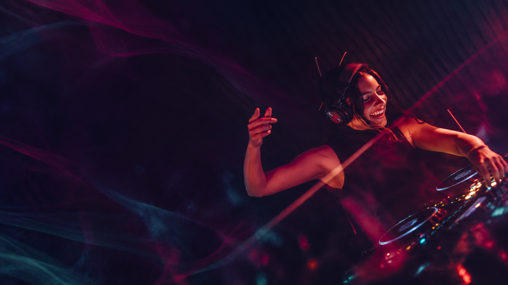 Savanna smiling behind the decks, surrounded by purple and blue light